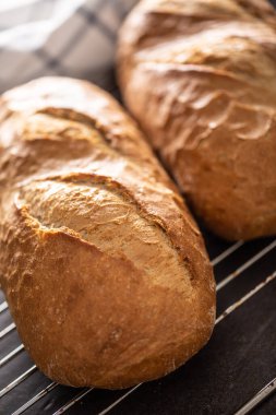 Metal ızgaraya yerleştirilmiş taze pişmiş ekmekler. Yakın plan portre.
