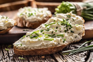 Geleneksel Slovak bryndza ile yakın plan ekmek dilimi. Koyun peynirinden yapılmış. Köy ahşabının üzerine taze kesilmiş soğanlar.