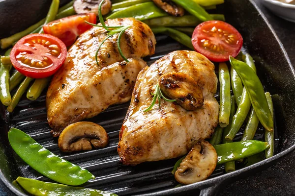 Primo piano di cibo cucinato in casa sano, pollo alla griglia in una padella con verdure verdi, funghi e pomodori — Foto Stock