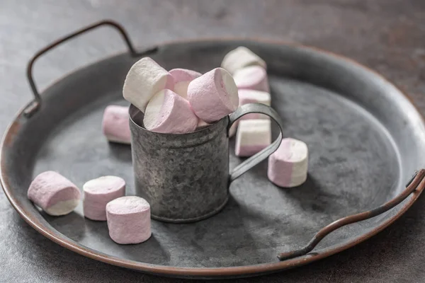 Metallic vintage bricka, yta och kopp med rosa och vit marshmallows inuti koppen och utspridda runt brickan — Stockfoto