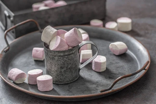 Metallic vintage bricka, yta och kopp med rosa och vit marshmallows inne i koppen och utspridda runt facket samt i metallic rutan i bakgrunden — Stockfoto