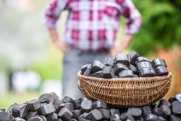 Mand Vol Met Steenkoolbriketten Een Stapel Met Een Man Achtergrond — Stockfoto