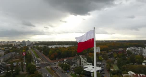 Zdjęcia lotnicze z polskiej flagi. Krąży po prawej stronie. Centrum miasta na tle — Wideo stockowe