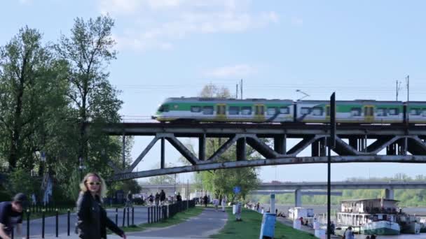 Um trem vai em uma ponte acima do povo — Vídeo de Stock
