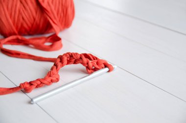 Kanca ve bir rulo pamuk iplikler Beyaz ahşap zemin üzerinde tığ işi. Tığ işi, hobi, iğne işi, kendini gerçekleştirme, yaratıcılık kavramı