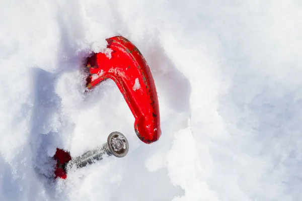 La vieille pince rouge dans la neige. Symbole des dérives de neige, des chutes de neige, des avalanches, des pertes de neige, du travail dans le froid. Espace de copie — Photo