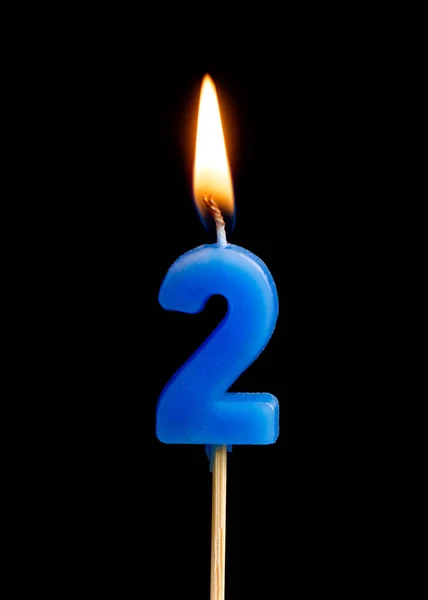 Burning candle in the form of two figures (numbers, dates) for cake isolated on black background. The concept of celebrating a birthday, anniversary, important date, holiday, table setting, cake decor — Stock Photo, Image