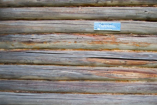 Vecchia parete di legno con l'iscrizione in russo "Harness". Sfondo, texture — Foto Stock