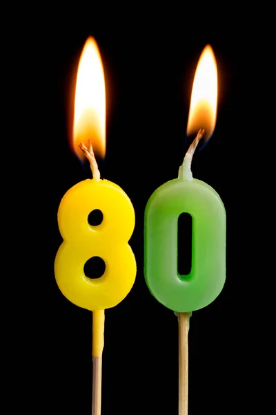 Горящие свечи в виде восьмидесяти фигурок (чисел, дат) для торта изолированы на черном фоне. Концепция празднования дня рождения, юбилея, важной даты, праздника, сервировки стола, торта d — стоковое фото
