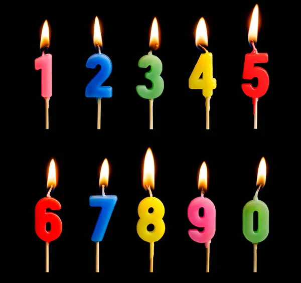 Queimar velas na forma de figuras (números, datas) para bolo isolado em fundo preto. O conceito de celebrar um aniversário, aniversário, data importante, feriado, configuração de mesa — Fotografia de Stock
