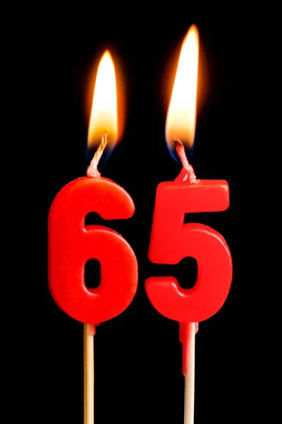Bougies brûlantes en forme de 65 soixante cinq chiffres (nombres, dates) pour gâteau isolé sur fond noir. Le concept de célébrer un anniversaire, un anniversaire, une date importante, des vacances, un arrangement de table — Photo
