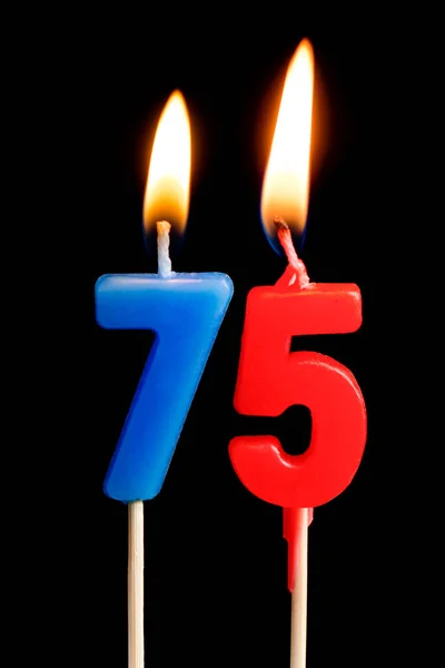 Velas ardientes en forma de 75 setenta y cinco figuras (números, fechas) para pastel aislado sobre fondo negro. El concepto de celebrar un cumpleaños, aniversario, fecha importante, día festivo, mesa settin — Foto de Stock