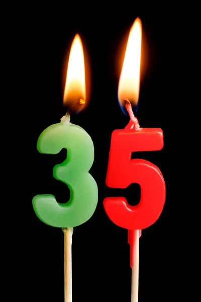 Burning candles in the form of 35 thirty five figures (numbers, dates) for cake isolated on black background. The concept of celebrating a birthday, anniversary, important date, holiday, table setting — Stock Photo, Image
