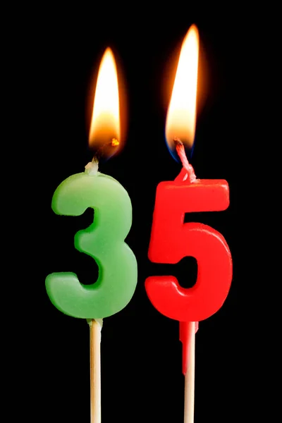 Velas ardientes en forma de 35 treinta y cinco figuras (números, fechas) para pastel aislado sobre fondo negro. El concepto de celebrar un cumpleaños, aniversario, fecha importante, día festivo, ajuste de mesa —  Fotos de Stock