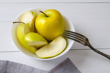 Beyaz bir tabak taze yeşil elma. Sağlıklı beslenme, Vejetaryenlik, çiğ gıda, sağlıklı beslenme, sağlıklı snack, kilo kaybı, diyet kavramı