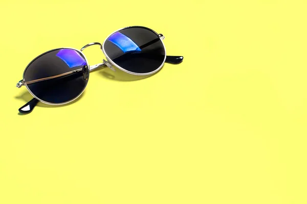 Stylish fashionable sunglasses isolated on a yellow background. The concept of sun, summer, holidays, vacations, travel — Stock Photo, Image