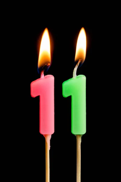 Brandende kaarsen in de vorm van 11 elf cijfers (getallen, datums) voor cake geïsoleerd op zwarte achtergrond. Het concept van het vieren van een verjaardag, een verjaardag, een belangrijke datum, een vakantie, een tabel instellen — Stockfoto