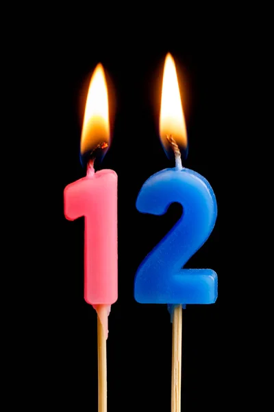 Burning candles in the form of 12 twelve figures (numbers, dates) for cake isolated on black background. The concept of celebrating a birthday, anniversary, important date, holiday, table setting — Stock Photo, Image