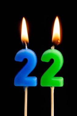 22 yirmi iki şeklinde mum yakma (sayılar, tarihler) siyah arka plan üzerine izole kek için. Kutluyor doğum günü, yıldönümü, önemli bir tarih, tatil, Tablo ayarı kavramı