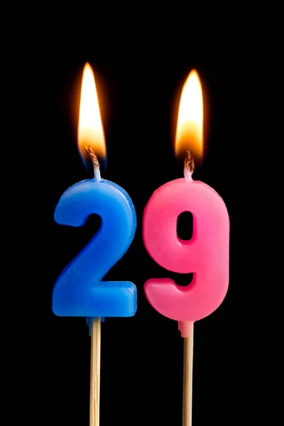 Burning candles in the form of 29 twenty nine (numbers, dates) for cake isolated on black background. The concept of celebrating a birthday, anniversary, important date, holiday, table setting