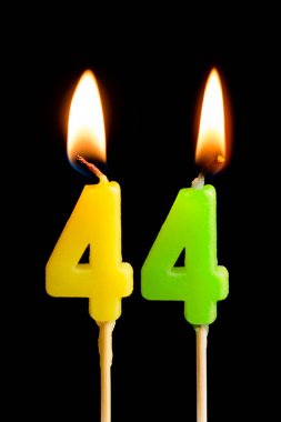 44 kırk dört şeklinde mum yakma (sayılar, tarihler) siyah arka plan üzerine izole kek için. Kutluyor doğum günü, yıldönümü, önemli bir tarih, tatil, Tablo ayarı kavramı