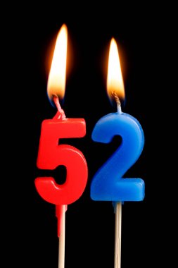 52 elli iki şeklinde mum yakma (sayılar, tarihler) siyah arka plan üzerine izole kek için. Kutluyor doğum günü, yıldönümü, önemli bir tarih, tatil, Tablo ayarı kavramı