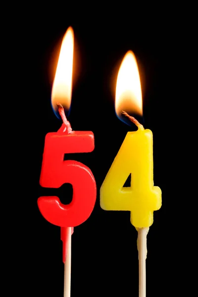 Velas ardientes en forma de 54 cincuenta y cuatro (números, fechas) para pastel aislado sobre fondo negro. El concepto de celebrar un cumpleaños, aniversario, fecha importante, día festivo, ajuste de mesa —  Fotos de Stock