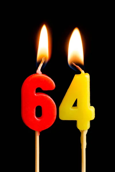 Αναμμένα κεριά με τη μορφή 64 εξήντα τέσσερα (αριθμοί, ημερομηνίες) για το κέικ που απομονώνονται σε μαύρο φόντο. Η έννοια της γιορτάζει ένα γενέθλια, επέτειο, σημαντική ημερομηνία, αργία, πίνακα ρύθμιση — Φωτογραφία Αρχείου