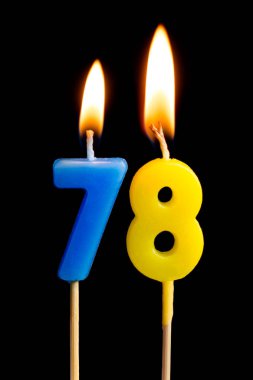 78 yetmiş sekiz şeklinde mum yakma (sayılar, tarihler) siyah arka plan üzerine izole kek için. Kutluyor doğum günü, yıldönümü, önemli bir tarih, tatil, Tablo ayarı kavramı