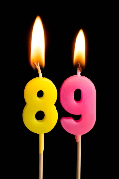 Зажигание свечей в виде 89 восемьдесят девять (номера, даты) для торта изолированы на черном фоне. Концепция празднования дня рождения, юбилея, важной даты, праздника, сервировки стола — стоковое фото