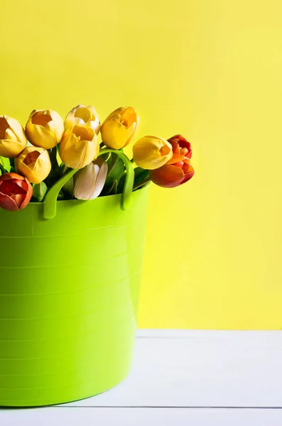 Buquê de tulipas amarelas, brancas e laranja em cesta jardim verde no fundo brilhante . — Fotografia de Stock