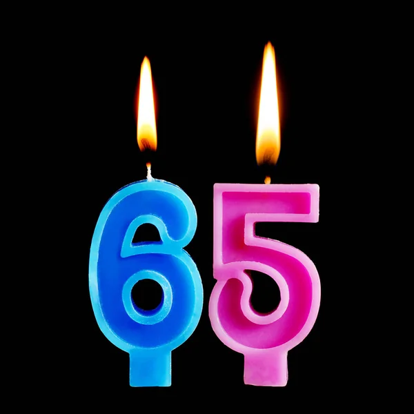 Velas ardientes en forma de 65 sesenta y cinco figuras para pastel aislado sobre fondo negro. El concepto de celebrar un cumpleaños, aniversario, fecha importante, día festivo — Foto de Stock