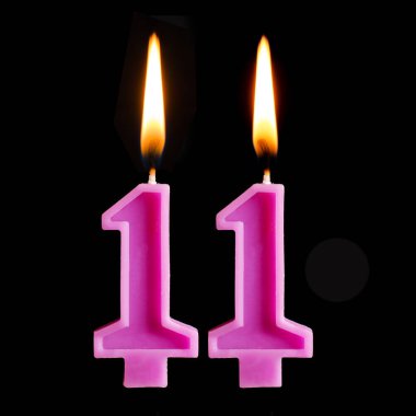 Doğum günü mumları 11 şeklinde yanan siyah arka plan üzerine izole kek için on rakamlar.