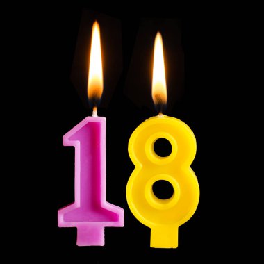 Doğum günü mumları 18 şeklinde yanan on sekiz rakamları veya siyah arka plan üzerine izole kek.
