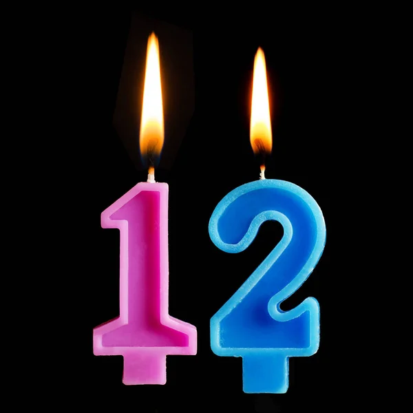 Queimando velas de aniversário na forma de 12 doze figuras para bolo isolado em fundo preto . — Fotografia de Stock
