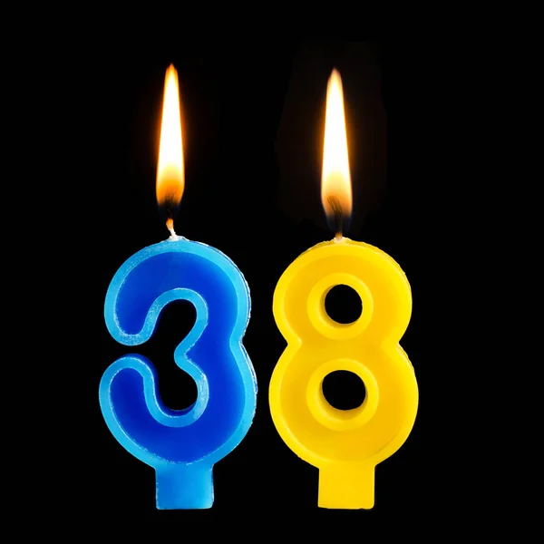 Bruciare candele di compleanno in forma di 38 trentotto per torta isolata su sfondo nero . — Foto Stock