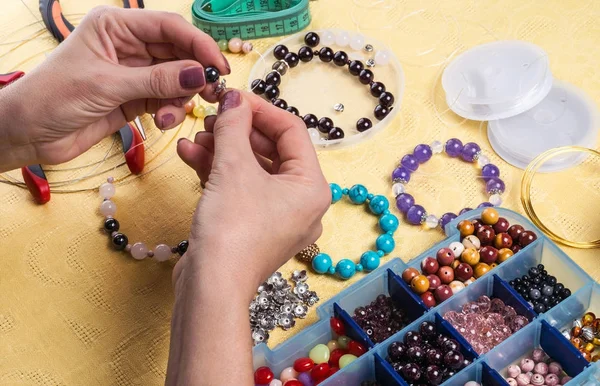 Making bracelet of colorful beads.