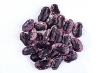 Bir avuç siyah-mor Barbunya beyaz bir arka plan üzerinde izole.