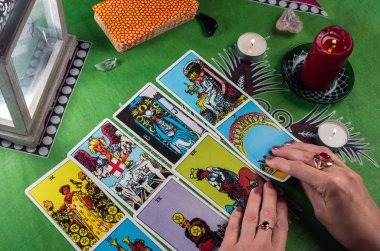 Kehanet tarot kartları bir arka plan üzerinde tarafından mum ile yeşil bir masa örtüsü. 