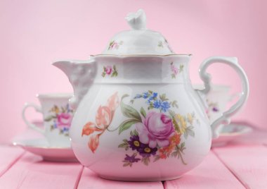 Çaydanlık bardak pembe bir arka plan üzerinde.