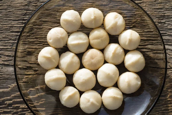 Een Handvol Pitten Macadamia Noten Transparante Schotel Achtergrond Van Grove — Stockfoto