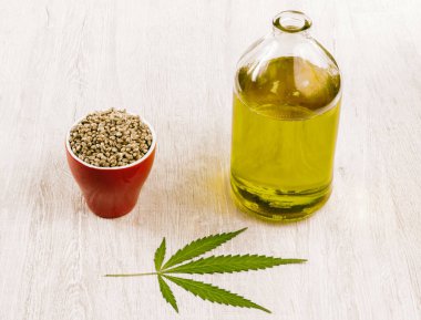 Kenevir yağı kenevir tohumu ve marihuana yaprağı bir grup ile bir şişe. 