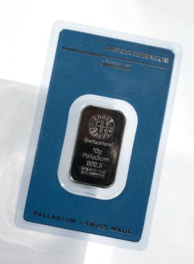 Kyiv, Ukraine - May 11, 2017: Minted bar of palladium weighing 10 grams sealed in tamper-proof packaging. Palladium ingot in blister package produced by the Swiss factory Argor-Heraeus. On a light gray background. clipart
