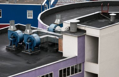 Ticari havalandırma sistemlerinin dış üniteleri endüstriyel bir binanın çatısına kurulmuştur..