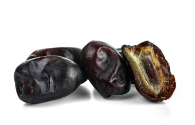 Bir kaç kuru hurma, bir bütün ve bir dilim. Beyaz arkaplanda izole.