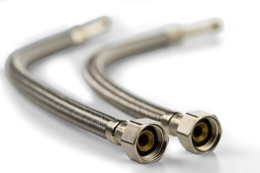 Su kaynaklarıyla bağlantı kurmak için metalik örülmüş su esnek hortumları. Beyaz arka planda. Seçici odak.