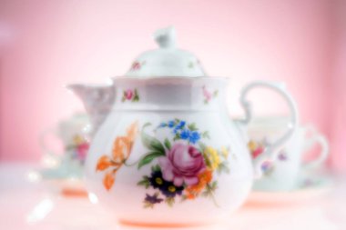 Pembe arka planda yumuşak odaklı bir çay seti. Seçici odak.