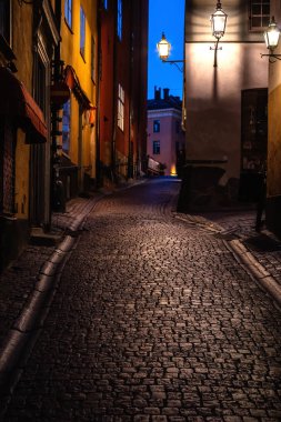 Gamla Stan 'in merkezindeki dar kaldırım taşı caddesi. Stockholm, İsveç. Akşam fotoğrafı. Seçici odak.