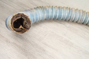 Tıkanmış plastik kanalizasyon borusu yerde yatıyor. Seçici odak.