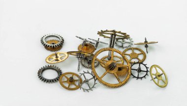 Beyaz arka planda çeşitli boyutlarda bir grup sarı metal dişli..